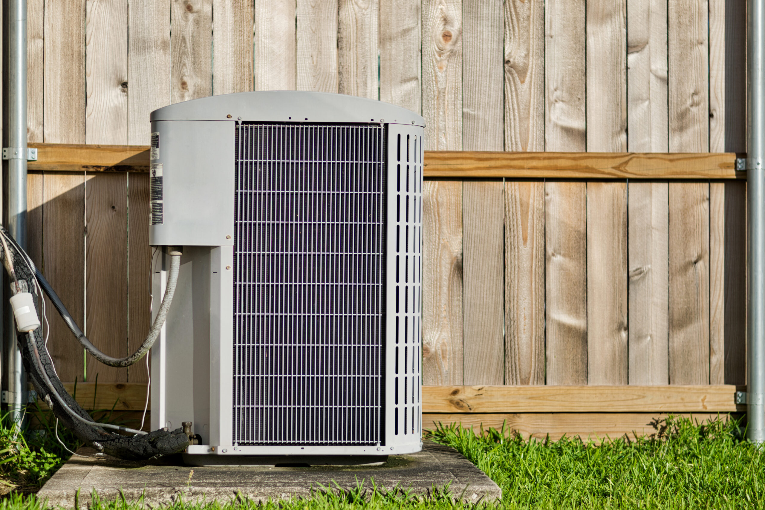 Central air conditioning unit in a residential backyard