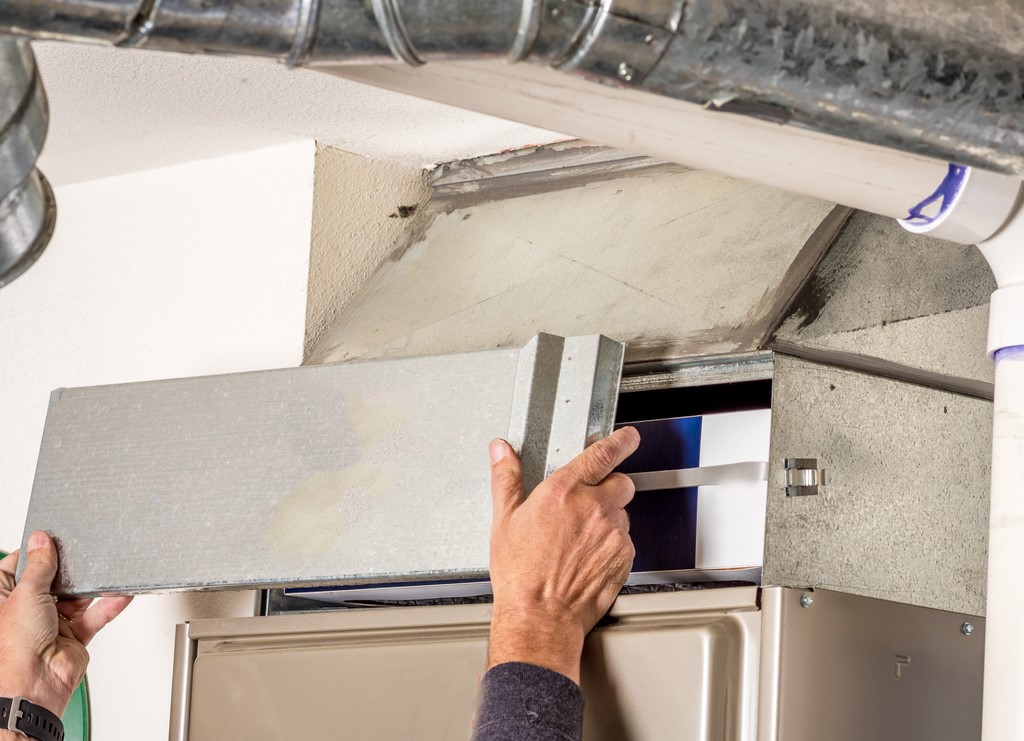 HVAC technician removing furnace access panel