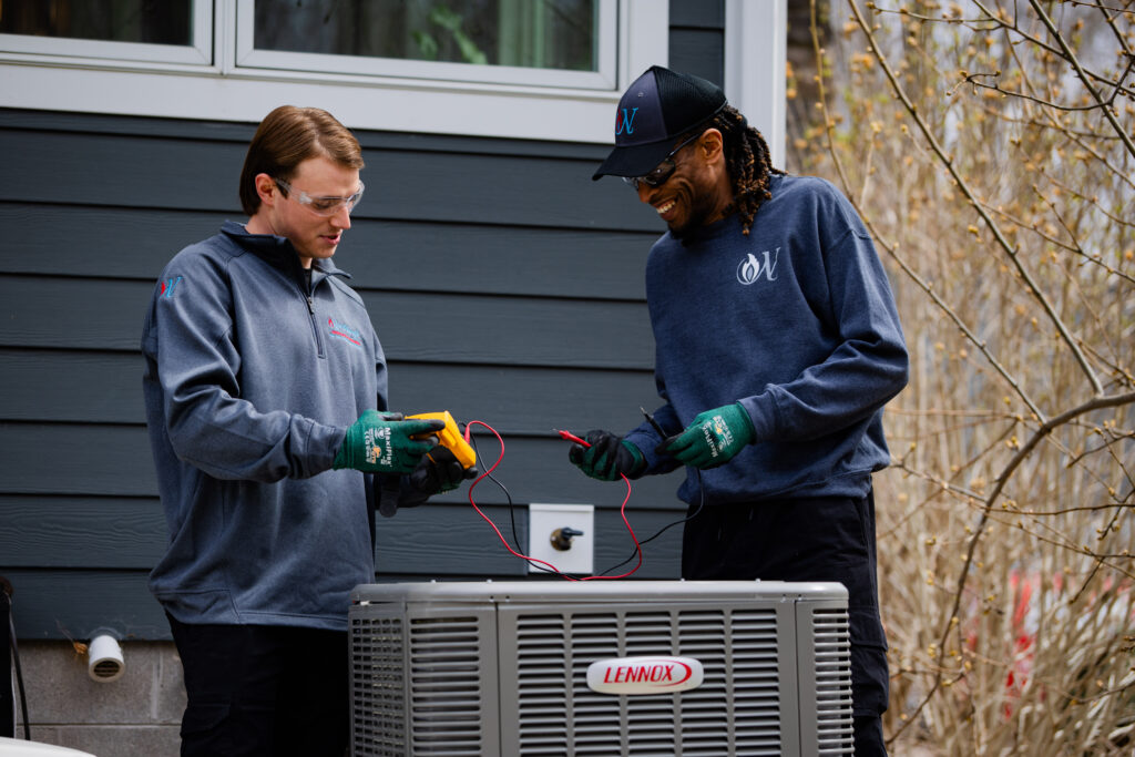 two Nerthlings technicians working on an AC unit